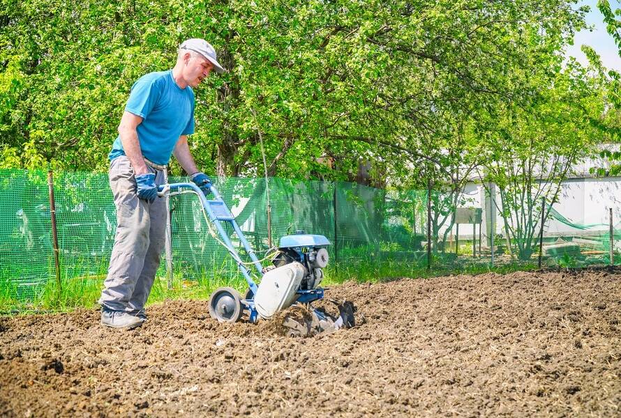 hombre con camiseta azul utilizando una motoazada